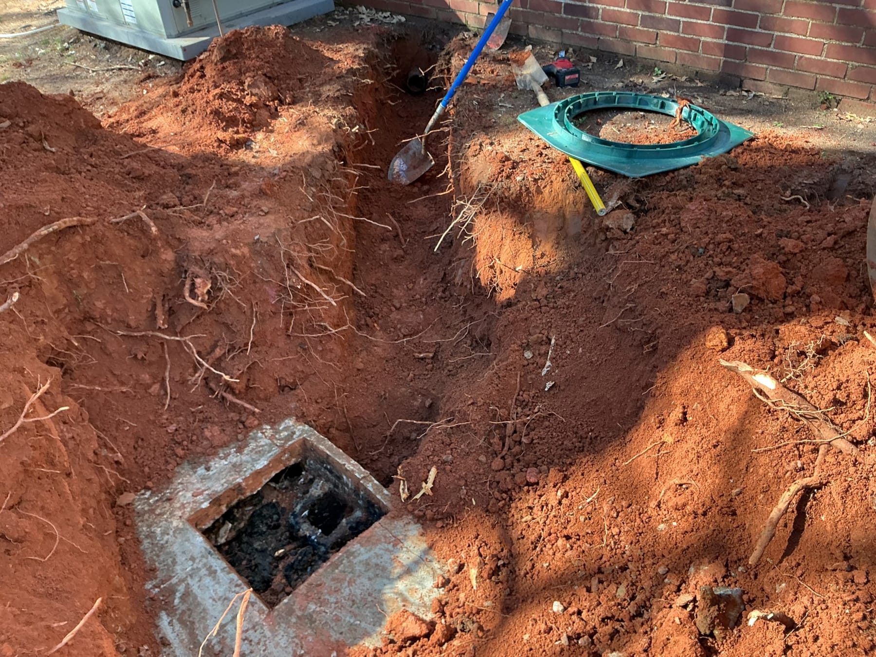 A septic distribution box set in the ground with its lid off.