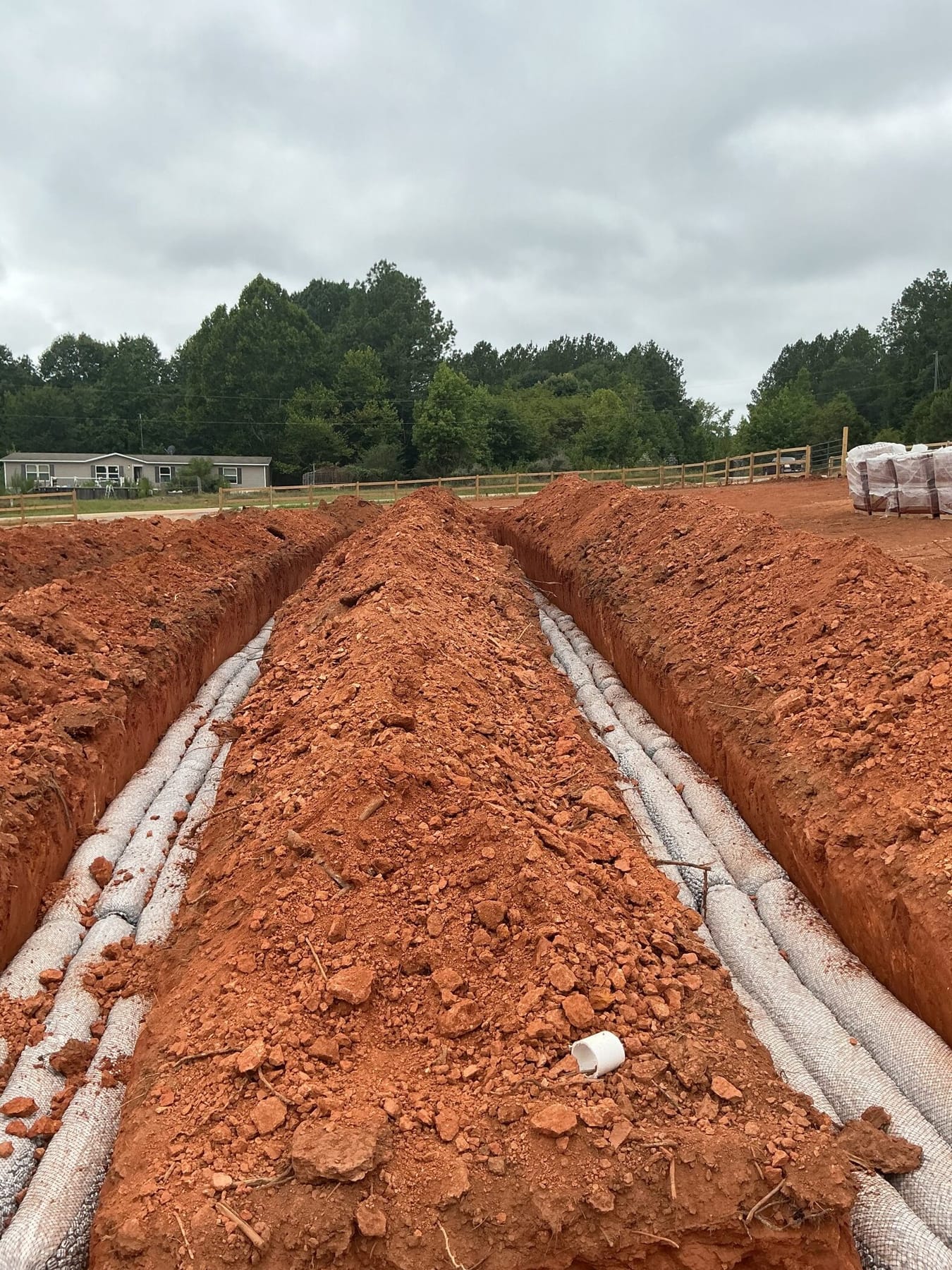 Two drain-field lateral trenches open on a lakeside lot.